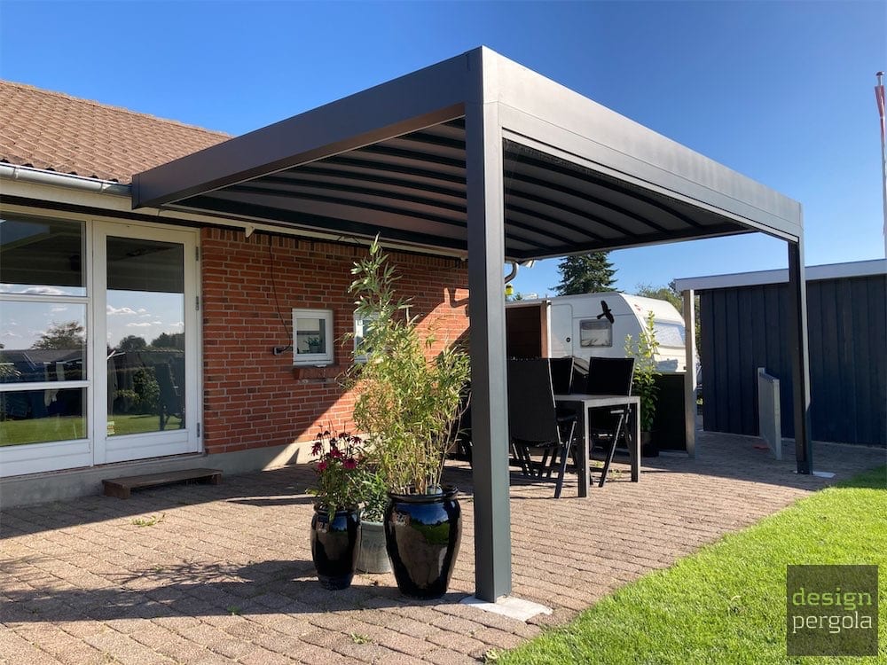 Kubisk pergolamarkise med tekstiltag og spiseplads ved rødt murstenshus i Aabenraa