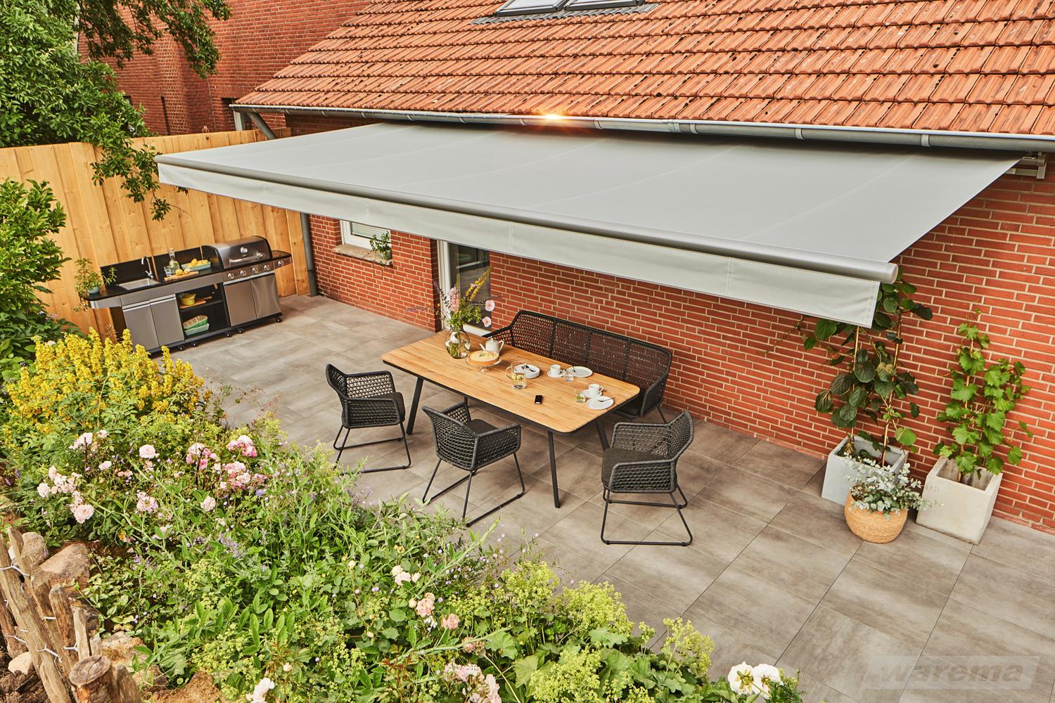 Bred WAREMA Terrea H60 over spiseplads ved et klassisk murstenshus