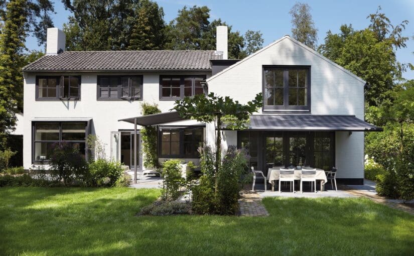 Faber markiser på stort hvidt hus med terrasse og have