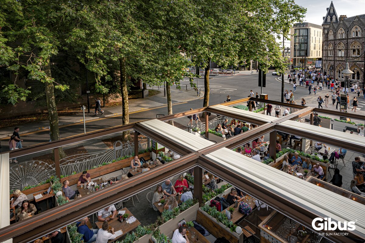 Restaurantterrasse med Gibus Zenit, hvor tekstiltaget er trukket tilbage over udeserveringen