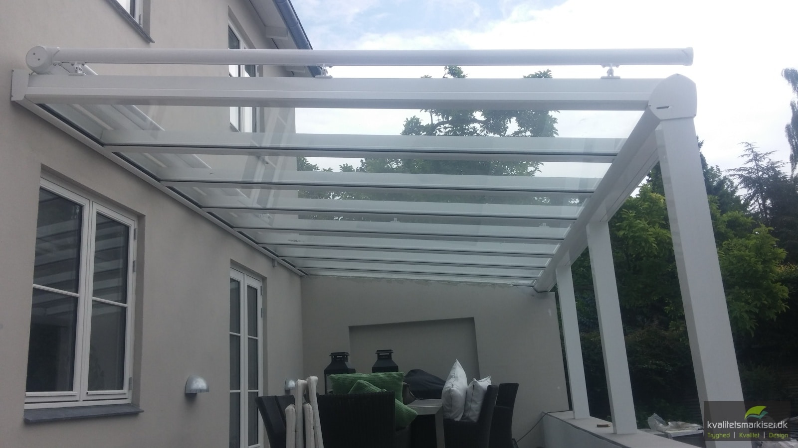 Hvid RIVA glasoverdækning med udvendige tagmarkiser over terrassen ved en villa i Charlottenlund