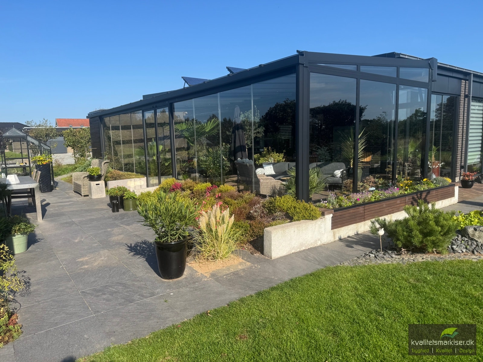 Terrasseoverdækning med glastag og store glassider ved en bolig i Rødekro