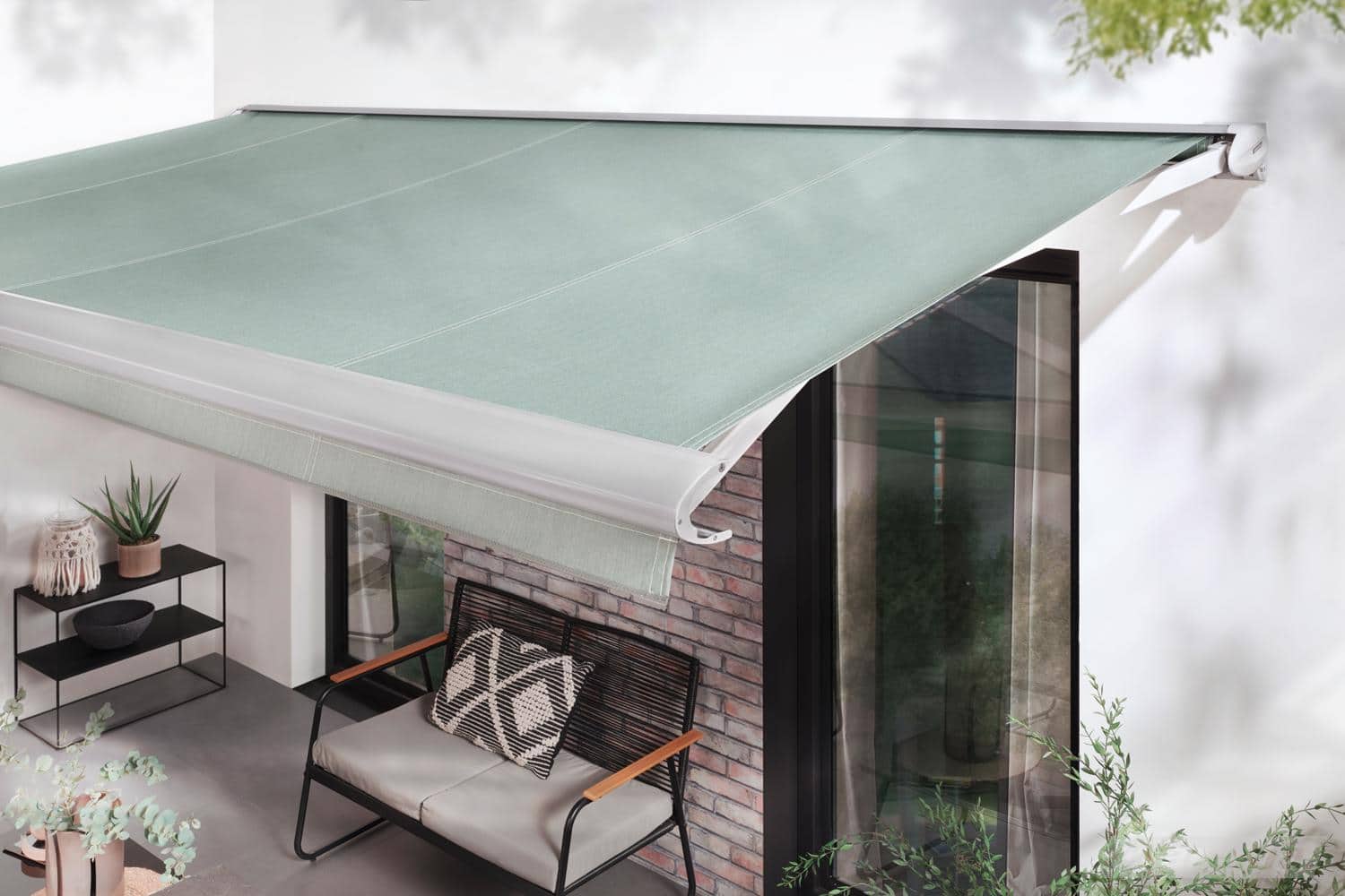 Terrea 550 skaber skygge ved en mindre terrasse foran et murstenshus