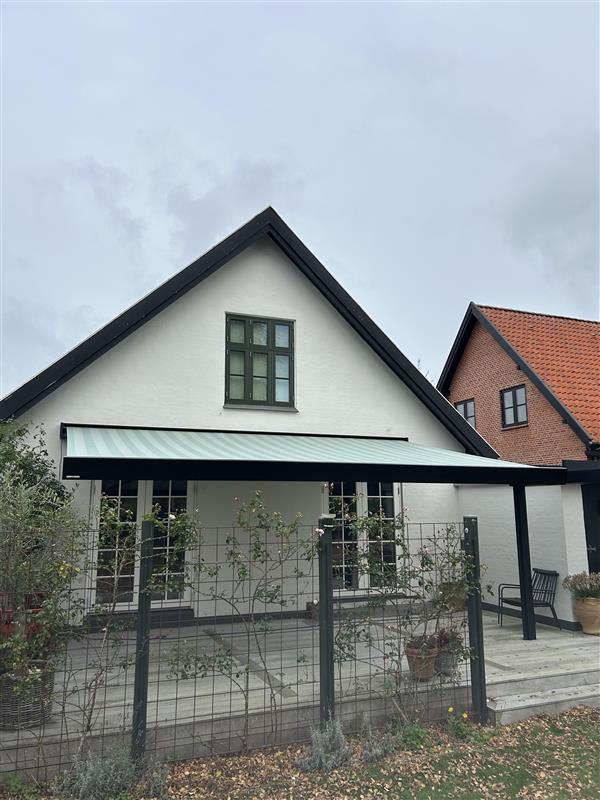 Weinor Kubata med stribet dug over træterrasse ved hvidt hus i Odense