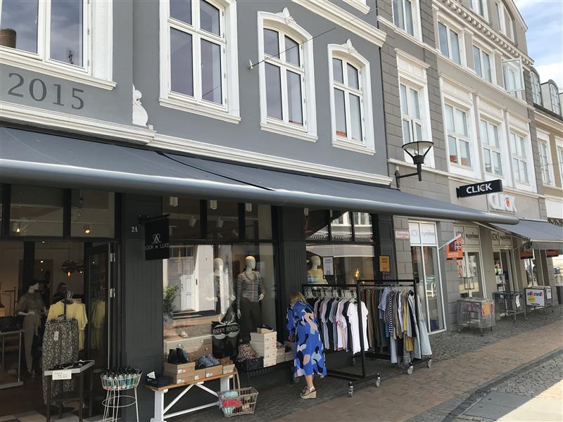 Grå Weinor Opal Design II butiksmarkise over vinduer og gadevarer hos Happy Hunting i Aabenraa