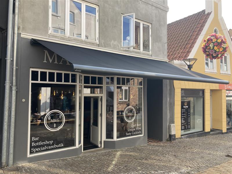 Udslået Weinor Opal Design II markise over indgang og butiksvinduer hos Malt & Grape i Aabenraa