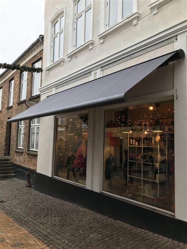 Grå Weinor Opal Design II butiksmarkise over butiksvinduer og indgang hos Norsk i Aabenraa