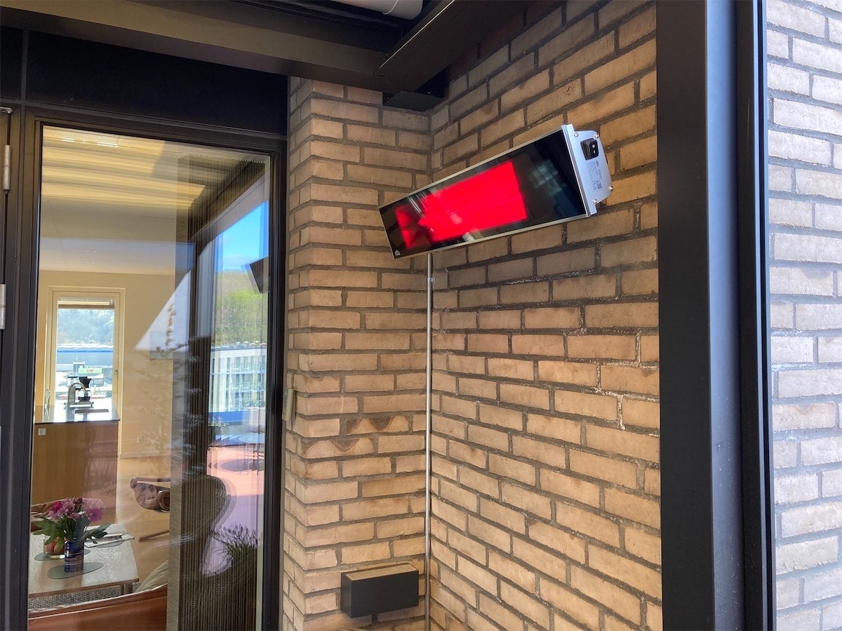 Tændt Frico Relax Glass io terrassevarmer på en overdækket terrasse