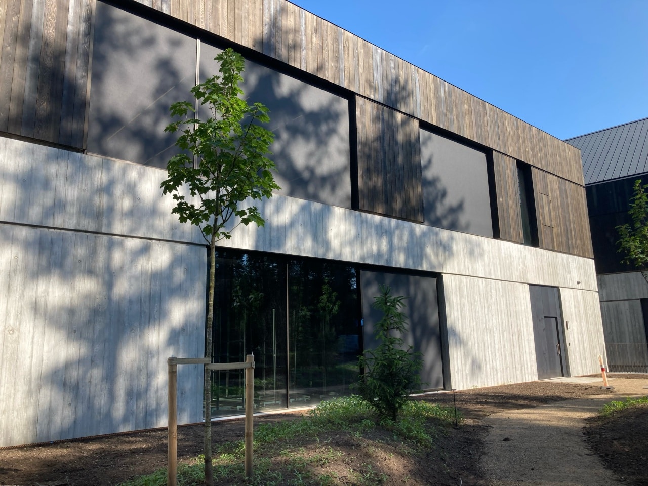 Integrerede screens i moderne bolig med træ- og betonfacade