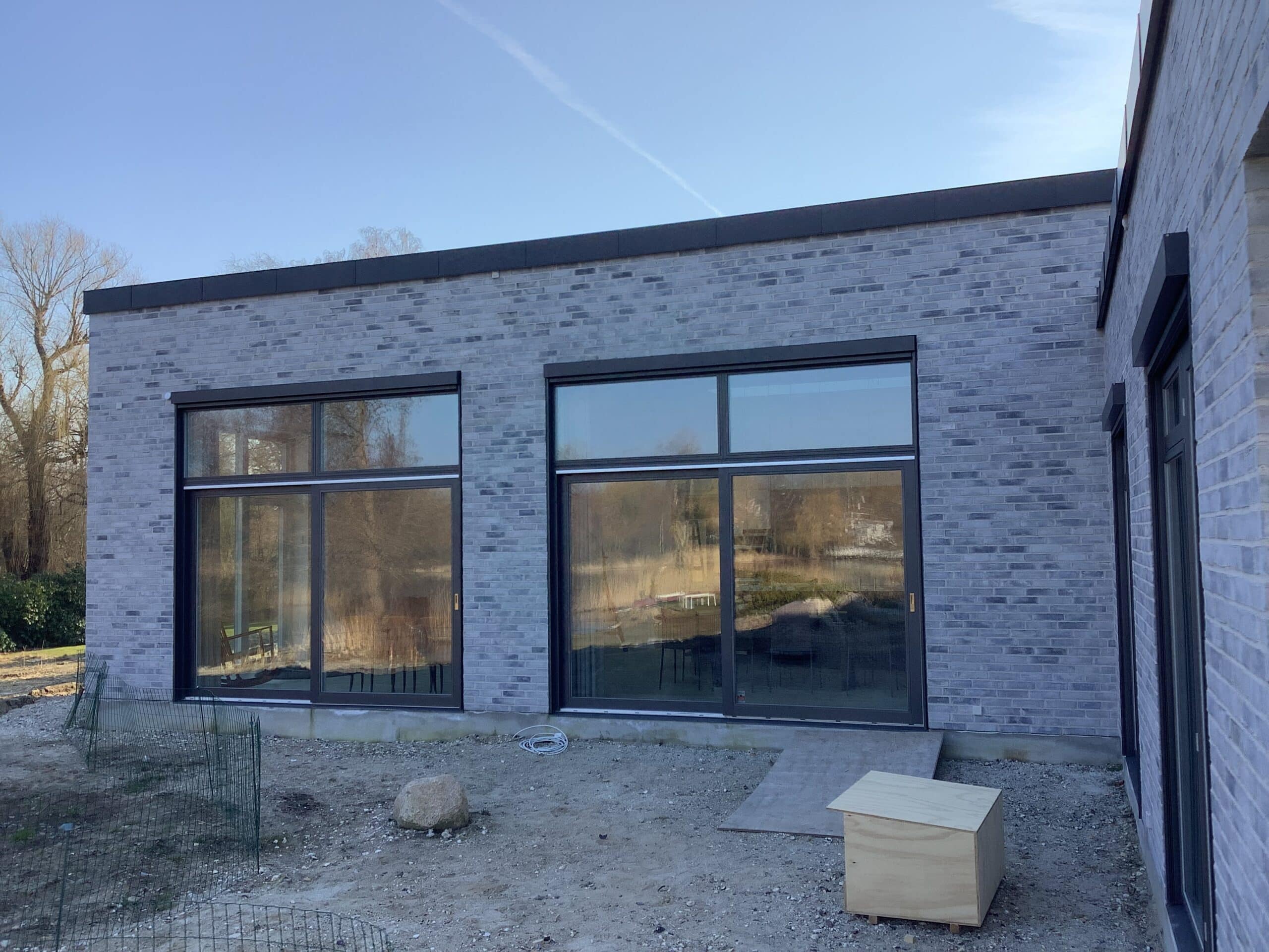 To store vinduespartier med Renson Fixscreen Minimal kørt op på et nybygget murstenshus