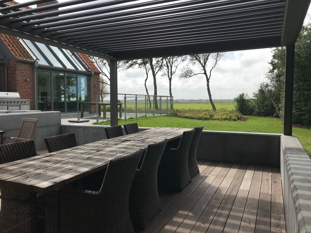 Uderum med pergola og spiseplads med udsigt over haven