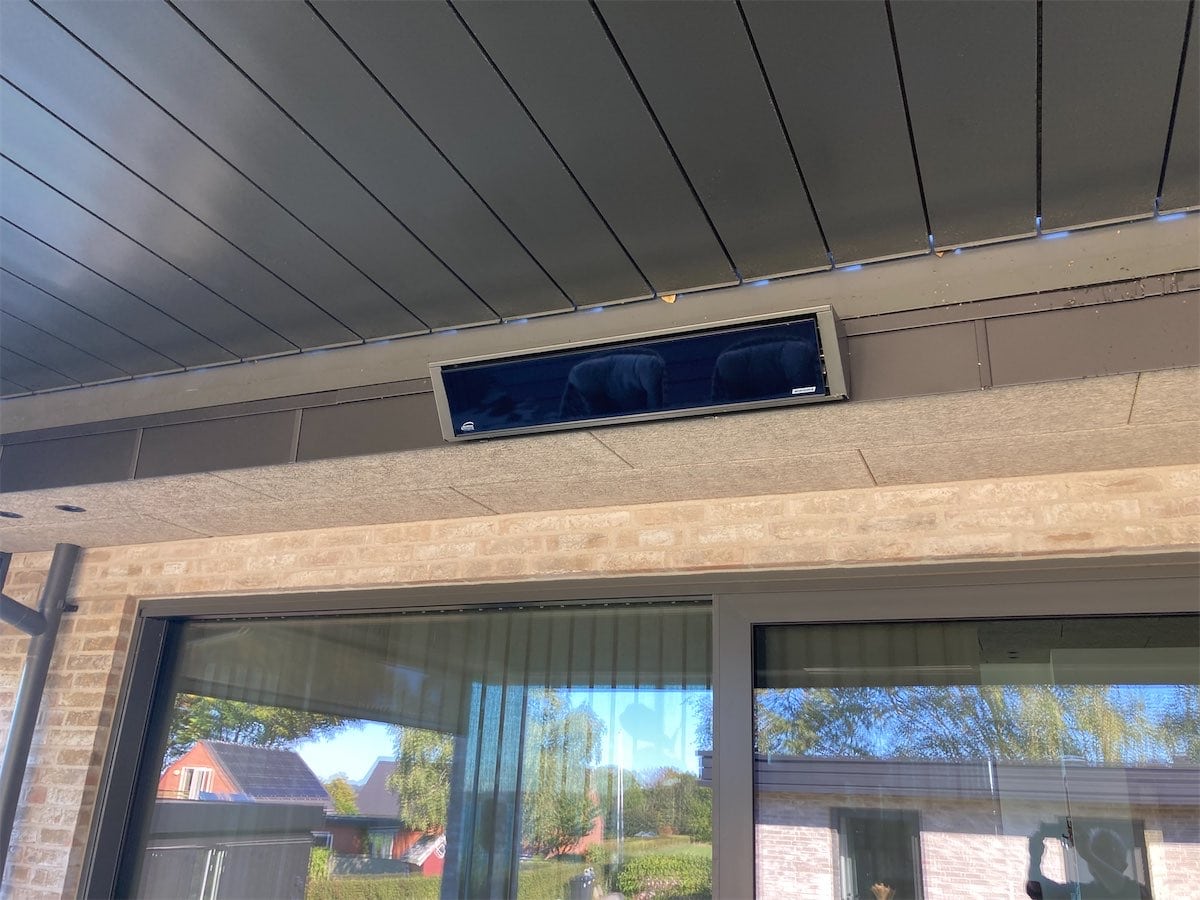 WAREMA Design heater med mørk glasfront monteret under et lameltag i Børkop