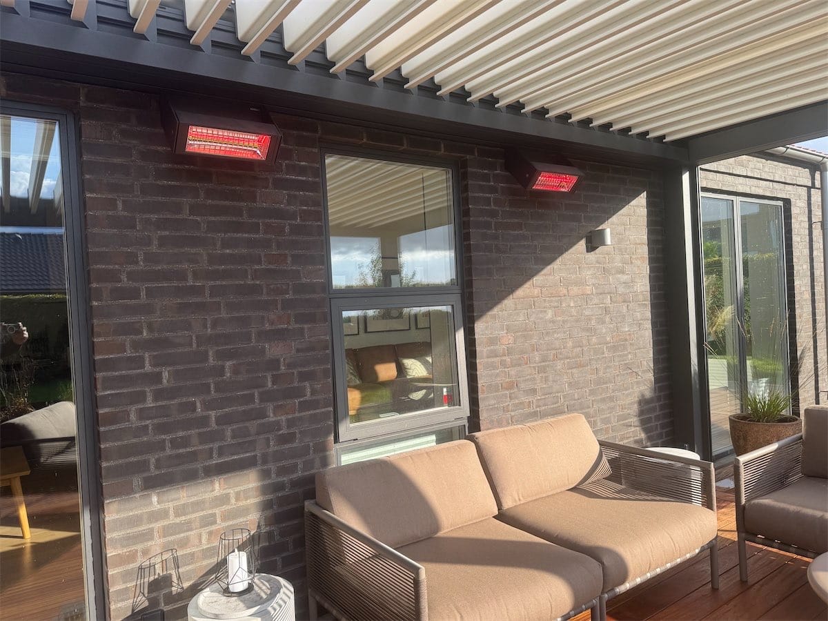 To tændte Weinor Tempura Quadra varmelamper over en siddeplads under en pergola i Ringsted