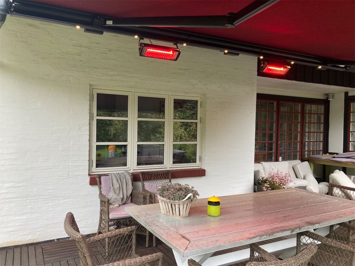 Rød markise over spisepladsen på en terrasse i Rungsted med integrerede varmelamper