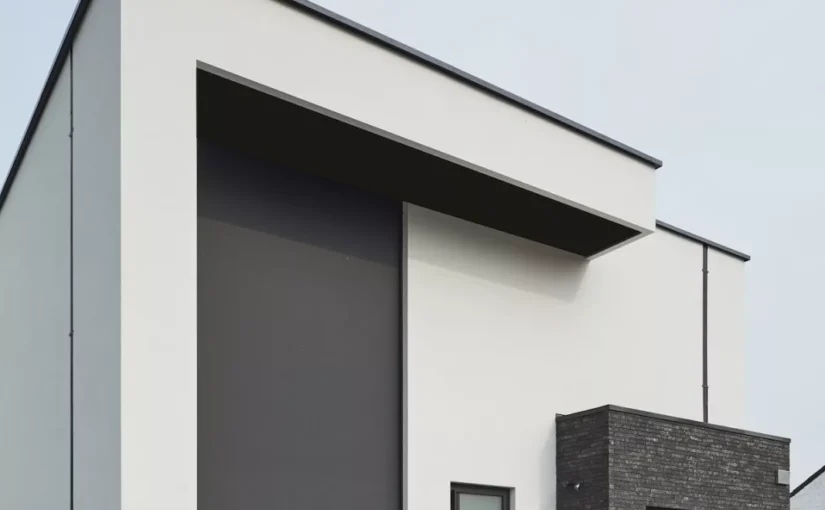 Høj Wilms screen delvist sænket foran et stort glasparti på et moderne hus